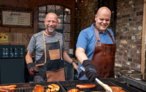 Gruppenevents Grill: Das Dümpenhofteam steht lachend am Grill und grillt